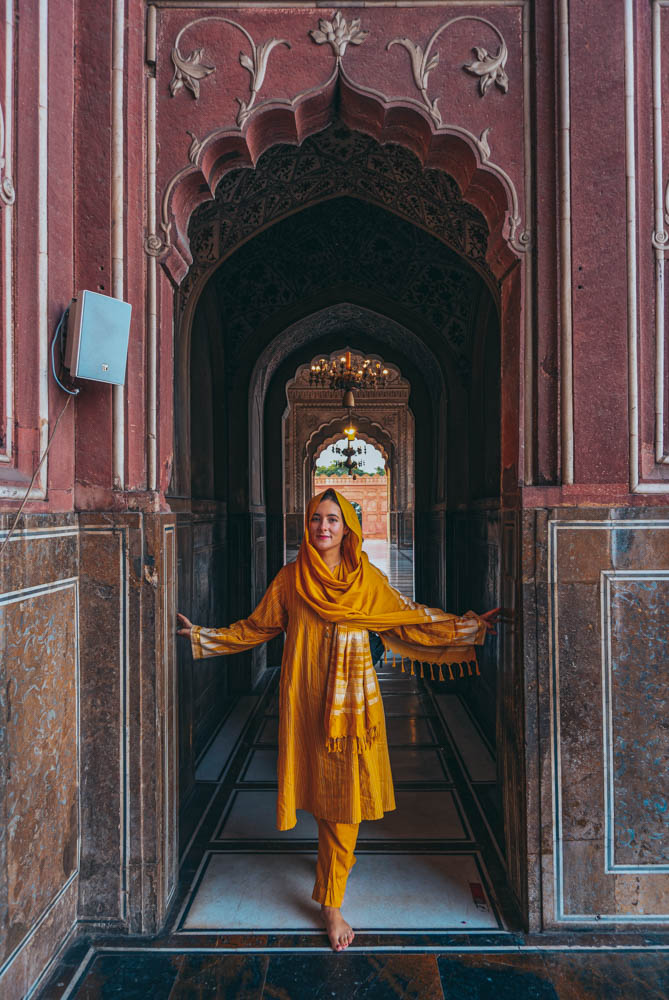 a western women wearing traditional Pakistan clothes of Shalwar-Kameez at Badshahi Mosque in Lahore, Pakistan