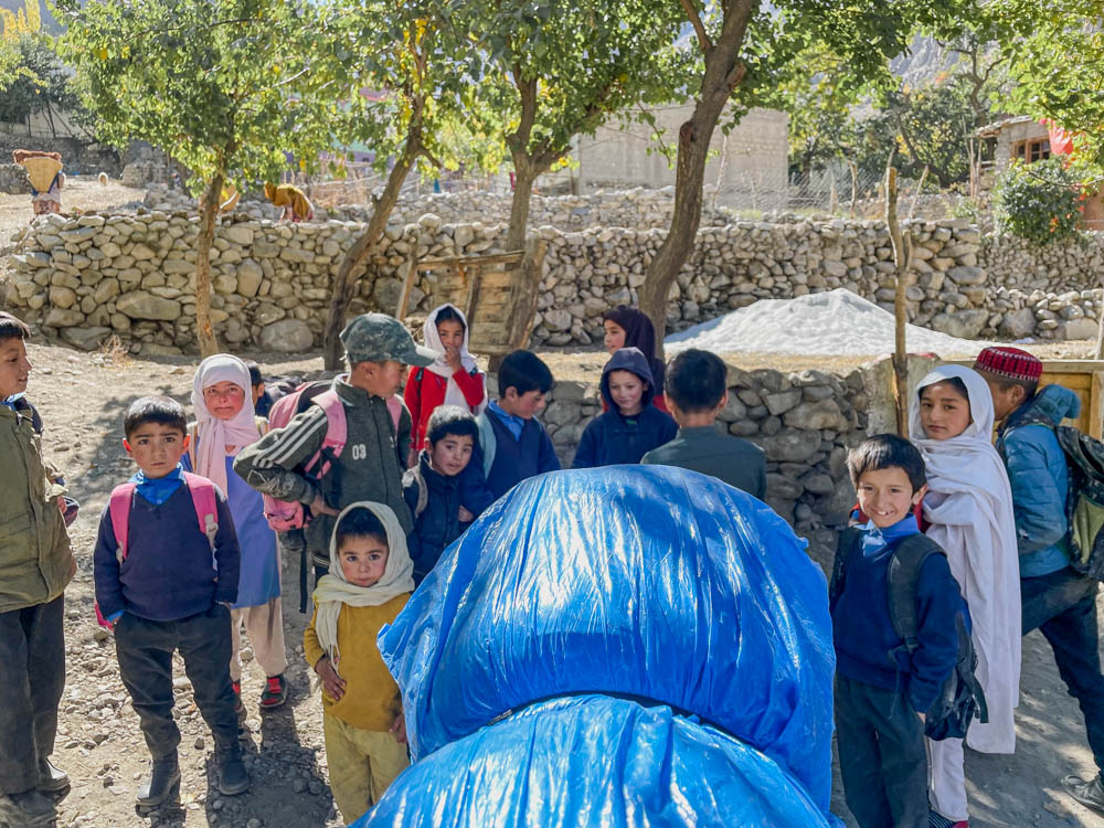 a group of young Pakistani children gathering around a western motorcycle tourist in Skardu, Pakistan
