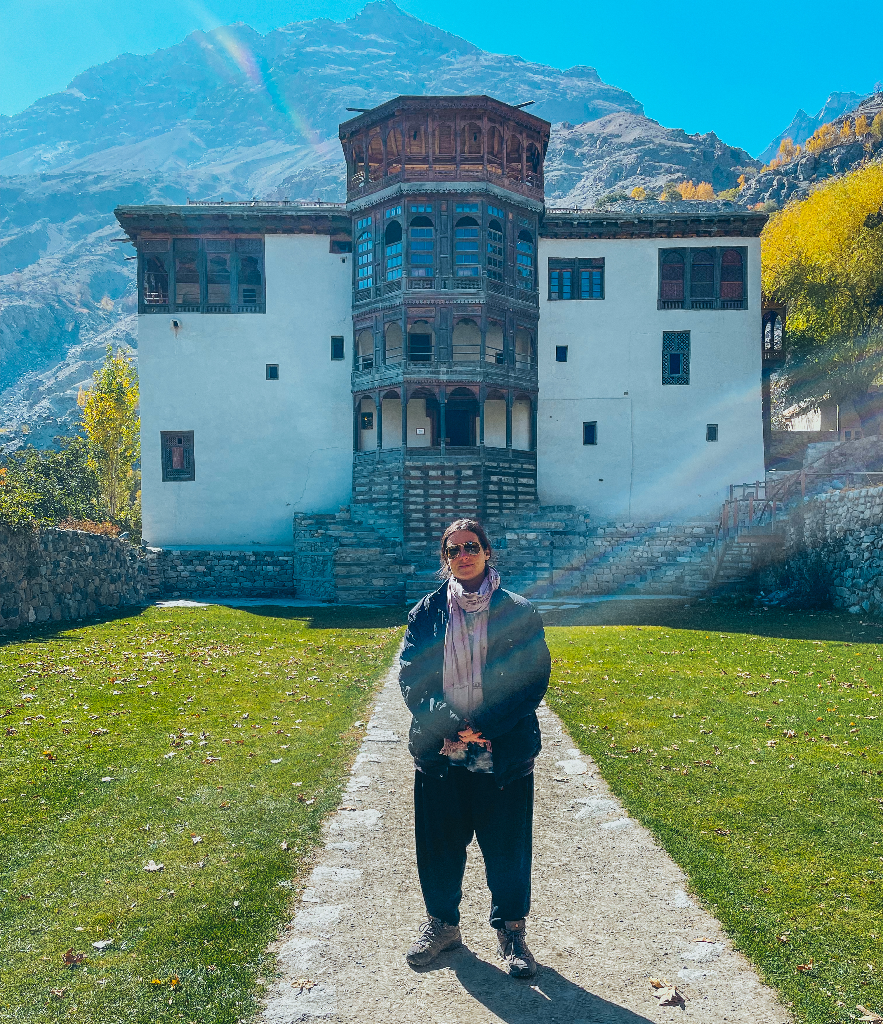 A backpacker smiling in front of Khaplu Fort